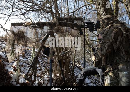 Les tireurs d'élite du groupe des forces spéciales 10th observent une cible lors de l'entraînement des tireurs d'élite sur une aire de répartition au cours d'un exercice d'entraînement bilatéral près de Kaunas, en Lituanie, en 9 mars 2022. La mission de formation de deux jours était un effort de partenariat avec la société lituanienne Jaeger SOF qui travaillait ensemble pour identifier une cible, tirer et quitter dans des conditions austères et solidifié un partenariat solide entre les forces alliées. Banque D'Images