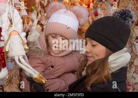 Prague - 13 décembre: Une jeune femme et sa jeune fille en vêtements d'hiver regardent les décorations et les jouets sur 13 décembre 2022 exposés au C Banque D'Images