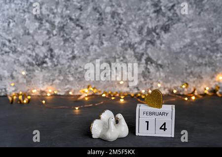 Un calendrier en bois avec la date 14 février et deux pigeons. concept de la saint-valentin. Photo de haute qualité Banque D'Images