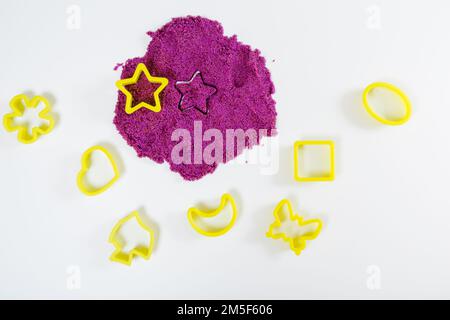 Sable cinétique violet, moules en plastique pour sable. Vue de dessus. Arrière-plan blanc Banque D'Images