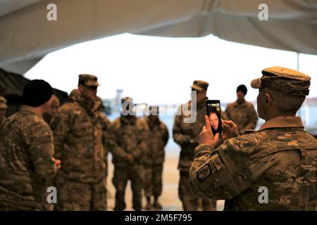 Le général de division Jeffery Broadwater, commandant adjoint du corps V, a parlé avec le sergent 1st de classe Christopher Battin, officier de contrôle de la production en charge, Compagnie Delta, 1-3rd Bataillon d'attaque, avant de lui présenter une pièce de monnaie lors d'une visite à la base aérienne de Lielvārde, 10 mars 2022. Le Sgt. Maj. Robert Christensen tenait le téléphone pour que la fille de Battin puisse regarder son père recevoir la pièce. Broadwater a rencontré les soldats du bataillon d'attaque 1-3rd et a reconnu quatre membres de l'unité pour leur performance. 1-3rd Bataillon d'attaque est arrivé en Lettonie d'Allemagne pour exe Banque D'Images