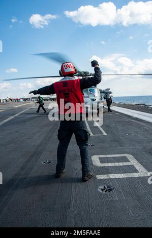 220311-N-DH793-1203 MER IONIENNE (11 mars 2022) Aviation Maintenance Administrationman 3rd classe Deandre Green, de New York, affecté aux 'Dragonslayerss' de l'Escadron de combat en mer (HSC) 11, dirige les pilotes d'un hélicoptère MH-60s Sea Hawk sur le plateau de vol du porte-avions de la classe Nimitz USS Harry S. Truman (CVN 75), 11 mars 2022. Le groupe de grève des transporteurs Harry S. Truman est en cours de déploiement aux États-Unis Sixième zone d'exploitation de la flotte à l'appui des intérêts des États-Unis, des alliés et des partenaires en Europe et en Afrique. Banque D'Images