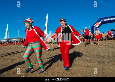 Les gens en robe de fantaisie courent vers la mer à l'organisme de bienfaisance RNLI Boxe DAP DIP à Southend on Sea, Essex, Royaume-Uni. Les nageurs se baignent en hiver dans l'estuaire de la Tamise Banque D'Images