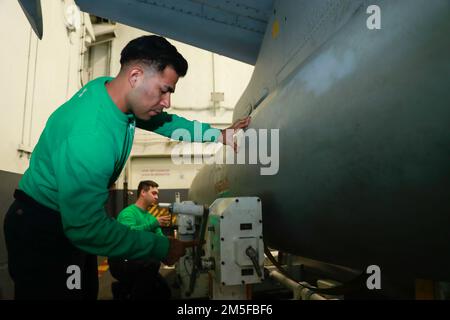 MER DES PHILIPPINES (11 mars 2022) Aviation Machiniste's Mate 2nd classe Angel Plascencia, front, de Stratford, Californie, Et le Mate 3rd de l'Aviation Machiniste de classe Justin Naehu, de Puna, HI, affecté aux "Black Aces" de l'escadron de combat Strike (VFA) 41, installe des réservoirs de carburant externes à un F/A-18F Super Hornet à bord du porte-avions de classe Nimitz USS Abraham Lincoln (CVN 72). Abraham Lincoln Strike Group est en cours de déploiement prévu dans la zone d'exploitation de la flotte américaine 7th afin d'améliorer l'interopérabilité par le biais d'alliances et de partenariats tout en servant de force d'intervention prête à l'emploi pour soutenir un libre Banque D'Images