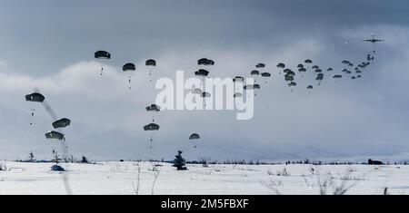 Les parachutistes du 1st Bataillon, 501st Régiment d'infanterie de parachutistes ainsi que les membres du 3rd Bataillon, Royal 22e Régiment de l'Armée canadienne se saisissent de la zone de Donnelly Drop pendant l'exercice joint Pacific multinational Readiness Centre 22-02 on 11 mars 2022. Le JPMRC 22-02 est le premier centre régional d'entraînement au combat en rotation en Alaska. Il se concentre sur les opérations de combat à grande échelle (LSCO) et est un événement d'entraînement par temps froid qui comprend un exercice d'entraînement de situation (STX) et un exercice de tir en direct (LFX) au 2QFY22. Cet exercice validera la formation par temps froid de l’équipe de combat de la Brigade Stryker 1/25th Banque D'Images