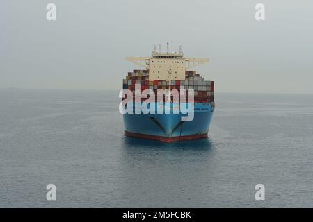 Énorme bateau-conteneur bleu de la compagnie maritime Maersk Lines ancré à la mer calme près du port de Koper. Banque D'Images