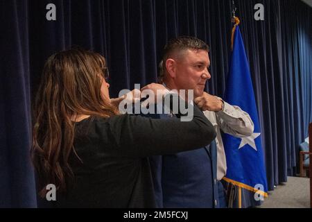 L'épouse et le père du Maj Robert Kolvet épingler son nouveau grade de lieutenant-colonel sur son uniforn pendant la cérémonie de promotion de Kolvet vendredi. 11 mars 2022 à la base de la Garde nationale aérienne du Nevada à Reno, au Nevada. Banque D'Images