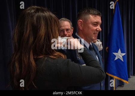 L'épouse et le père du Maj Robert Kolvet épingler son nouveau grade de lieutenant-colonel sur son uniforn pendant la cérémonie de promotion de Kolvet vendredi. 11 mars 2022 à la base de la Garde nationale aérienne du Nevada à Reno, au Nevada. Banque D'Images