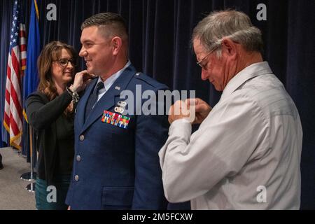 L'épouse et le père du Maj. Robert Kolvet épingler son nouveau grade de lieutenant-colonel sur son uniforme vendredi, lors de la cérémonie de promotion de Kolvet. 11 mars 2022 à la base de la Garde nationale aérienne du Nevada à Reno, au Nevada. Banque D'Images