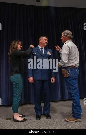 L'épouse et le père du Maj. Robert Kolvet épingler son nouveau grade de lieutenant-colonel sur son uniforme vendredi, lors de la cérémonie de promotion de Kolvet. 11 mars 2022 à la base de la Garde nationale aérienne du Nevada à Reno, au Nevada. Banque D'Images