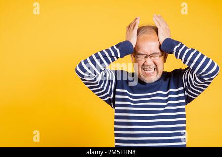 Homme asiatique aîné mains tenant la tête et les oreilles proches souffrant de maux de tête Banque D'Images