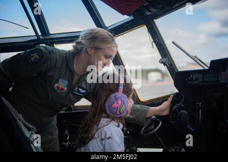 ÉTATS-UNIS Stephanie Stewart, capitaine de la Force aérienne, commandant de l'aéronef HC-130J combat King II, du 71st Escadron de sauvetage, enseigne à un enfant comment utiliser un joug sur un aéronef HC-130J pendant la journée portes ouvertes de la jeunesse à la base aérienne Moody, en Géorgie (12 mars 2022). Le 6 septembre 2019, six aviateurs du groupe de sauvetage 347th ont effectué le premier vol de l’aéronef de combat King II HC-130J devant être exploité par une équipage entièrement féminin. L'Open House de la jeunesse a culminé les femmes dans la semaine de l'aviation et avait pour but de connecter une jeune génération aux aviateurs et des inspirer pour des carrières dans la puissance aérienne menant à une force aérienne plus diversifiée et plus efficace Banque D'Images