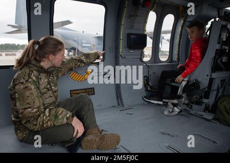 ÉTATS-UNIS Le capitaine de la Force aérienne Abby Norwood, pilote HH-60W Jolly Green II du 41st Escadron de sauvetage, enseigne à un enfant un affichage multifonctionnel sur un hélicoptère HH-60W pendant la journée portes ouvertes de la jeunesse à la base aérienne Moody, en Géorgie (12 mars 2022). Un MFD est utilisé pour afficher des informations importantes à l'équipage à bord de l'appareil pendant le vol. L'Open House de la jeunesse a culminé les femmes dans la semaine de l'aviation et visait à connecter une jeune génération aux aviateurs et aux inspirer pour des carrières dans l'aviation conduisant à une force aérienne plus diversifiée et plus efficace dans l'avenir. Banque D'Images