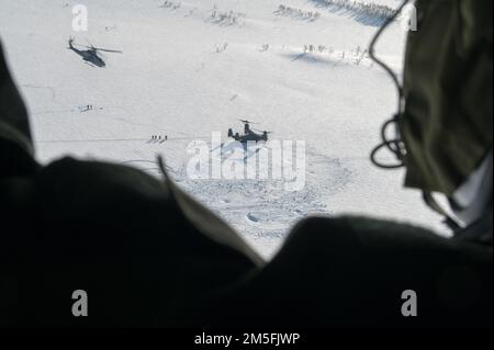 Une marine américaine avec l'aile d'avions marins 2nd à bord d'un UH-1Y Venom fournit une surveillance aux côtés d'un AH-1W Super Cobra tandis qu'un US Air Force CV-22B Osprey affecté à l'escadre d'opérations spéciales 352d débarquant dans une zone d'atterrissage de combat hostile simulée, le 12 mars 2022, Au cours de l'exercice Cold Response «22 dans le nord de la Norvège. Cette formation a été menée afin de mieux familiariser chaque unité avec les tactiques et les protocoles de l'autre. L'exercice Cold Response '22 est un exercice annuel de préparation nationale et de défense norvégien qui a lieu dans toute la Norvège, avec la participation de chacun de ses militaires Banque D'Images