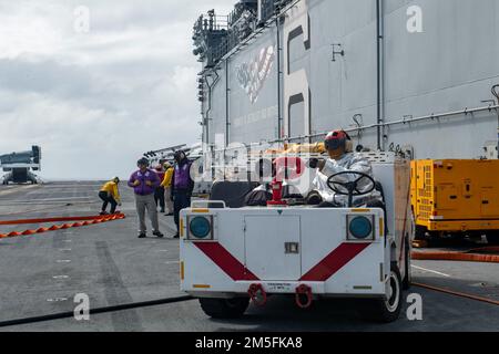 MER DES PHILIPPINES (13 mars 2022) Aviation Boatswain’s Mate (Handling) Airman Taijoon Adkins, de Lancaster, en Californie, affecté au navire d’assaut amphibie déployé à l’avant USS America (LHA 6), engage un tir d’avion simulé avec le tracteur de l’équipe d’accident et de sauvetage lors d’un exercice de contrôle des dommages d’aviation sur le pont de vol du navire. L'Amérique, navire principal de l'America Amphiobie Ready Group, ainsi que l'unité expéditionnaire maritime 31st, opère dans la zone de responsabilité de la flotte américaine 7th afin d'améliorer l'interopérabilité avec les alliés et les partenaires et de servir de force de réponse prête à d Banque D'Images