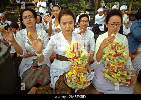 Un clan balinais menant un rituel pour honorer et purifier les esprits des membres de leur famille tardive, sur une plage près du temple Goa Lawah à Dawan, Klungkung, Bali, Indonésie. Banque D'Images