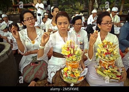 Un clan balinais menant un rituel pour honorer et purifier les esprits des membres de leur famille tardive, sur une plage près du temple Goa Lawah à Dawan, Klungkung, Bali, Indonésie. Banque D'Images