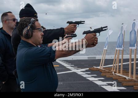 220313-N-XB010-1004 MER DE CHINE DE L'EST (13 mars 2022) technicien en équipement de soutien de l'aviation 2nd classe José Gonzalez, de New Haven, Connecticut, tire une arme de poing 9mm lors d'une fusillade sur le pont de vol de l'USS New Orleans (LPD 18). La Nouvelle-Orléans, qui fait partie de l'America Amphiobie Ready Group, ainsi que de l'unité expéditionnaire maritime 31st, opère dans la zone de responsabilité de la flotte américaine 7th afin d'améliorer l'interopérabilité avec les alliés et les partenaires et de servir de force de réaction prête à l'emploi pour défendre la paix et la stabilité dans la région Indo-Pacifique. Banque D'Images