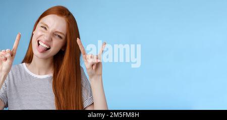 Oser insouciance ludique excitée bonne-regardant drôle redhead fille ayant le plaisir montrez l'affaissement de la languette faites de la grimace ravie faire du métal lourd rock-n-roll signe Banque D'Images