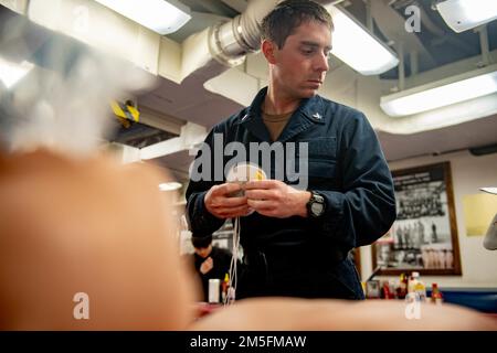 220314-N-UJ411-1058 OCÉAN PACIFIQUE (14 mars 2022) Cryptologic Technician (Collection) 3rd classe Mark Howard, de Sacramento, en Californie, apprend à utiliser un DAE à bord d'un destroyer à missile guidé de classe Arleigh Burke USS Spruance (DDG 111). Abraham Lincoln Strike Group est en cours de déploiement prévu dans la zone d'exploitation de la flotte américaine 7th afin d'améliorer l'interopérabilité par le biais d'alliances et de partenariats tout en servant de force de réaction prête à l'emploi pour soutenir une région libre et ouverte d'Indo-Pacifique. Banque D'Images