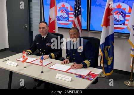 Arrière le sous-ministre Michael Johnston, commandant de la Garde côtière des États-Unis le neuvième district signe l'entente de l'Annexe géographique des Grands Lacs (CANUSLAK) avec Marc-André Meunier, sous-commissaire de la région du Centre Garde côtière canadienne, à Montréal, 14 mars 2022. L'entente CANUSLAK est un plan d'annexe opérationnel au Plan conjoint bilatéral d'urgence sur la pollution marine entre les États-Unis et le Canada. Banque D'Images