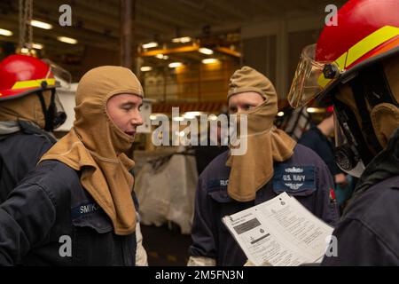 Les marins affectés à l'USS Gerald R. Ford (CVN 78) communiquent entre eux lors d'une évolution de lutte contre l'incendie, 14 mars 2022. Ford est dans le port de la Station navale de Norfolk et exécute une phase de base sur mesure avant le premier déploiement opérationnel du navire. Banque D'Images