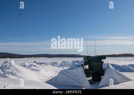 Un F-16 survole un système de défense aérienne Avenger pendant l'exercice ARCTIC EDGE 2022 à la base aérienne d'Eielson, Alaska, 14 mars 2022. Le F-16s a survolé les Avengers pour fournir aux gardes nationaux de Floride une formation réaliste de défense aérienne dans un environnement austère arctique. Banque D'Images