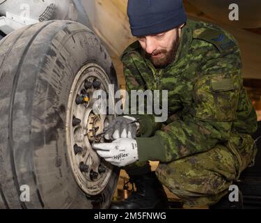 Le Caporal David Bouchard, technicien de la Force aérienne royale du Canada de la 3 e Escadre Bagotville (Québec), effectue l’entretien de routine du pneu CF-18 de la Force aérienne royale du Canada pendant l’opération Noble Defender de Thule AFB (Groenland), en mars. 15, 2022. L'opération NOBLE DEFENDER 22-2 du NORAD est une opération de défense aérienne qui s'étend de 14 mars à 17, 2022, impliquant divers aéronefs militaires de la Royal Canadian Air Force (ARC) et de la United States Air Force. Le personnel et les aéronefs sont basés à la station des Forces canadiennes Alert, Nunavut; Whitehorse, Yukon; Yellowknife, Territoires du Nord-Ouest; a Banque D'Images