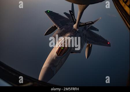 A ÉTATS-UNIS Air Force F-22 Raptor reçoit du carburant d'un américain Force aérienne KC-135 Stratotanker affecté au 340th Expeditionary Air ravitaillement Squadron, au-dessus des États-Unis Zone de responsabilité du Commandement central, 14 mars 2022. Le F-22 Raptor est un avion de cinquième génération qui combine furtivité, supercroisière, manœuvrabilité, avionique intégrée, et est conçu pour projeter la domination aérienne, rapidement et à de grandes distances et décourager les agresseurs régionaux lorsqu'ils sont déployés dans l'AOR USCENTCOM. Banque D'Images