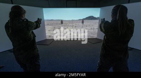 Les aviateurs allemands de la force aérienne du quartier général de l'OTAN, le Commandement aérien allié, tirent sur des cibles avec M18 pistolets tout en utilisant une salle de simulation à 300 degrés à la base aérienne de Ramstein, en Allemagne, au 15 mars 2022. L'utilisation du simulateur permet aux formateurs de passer plus de temps à analyser les performances et la forme de manière critique. Banque D'Images