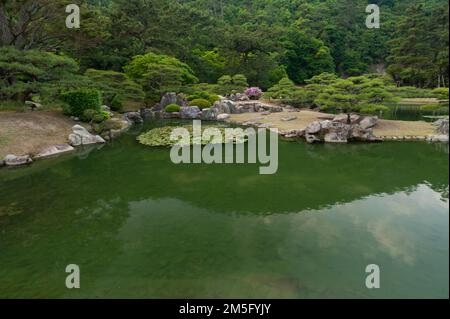 Détail du jardin de l'étang, soutenu par des "paysages empruntés" au jardin de Koen Ritsurin, Takamatsu, Japon. Banque D'Images