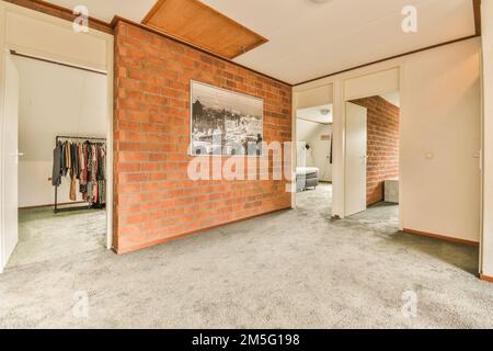 un mur de briques rouges accroché sur le côté d'une porte blanche dans une pièce avec moquette et murs Banque D'Images