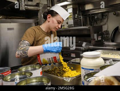 OCÉAN ATLANTIQUE (16 mars 2022) – Spécialiste culinaire 3rd classe Alexandrie Martinez ajoute une boîte de maïs à la cassolette de haricots verts dans la galerie du navire à bord du destroyer de missiles guidés de classe Arleigh Burke USS porter (DDG 78), 16 mars. Le USS porter, déployé à Rota, en Espagne, participe actuellement à l'exercice de la Force opérationnelle dans la zone d'opérations de la flotte américaine 2nd. Le TTEX sert d'exercice de certification pour le déploiement indépendant des navires et est conçu pour tester la préparation et le rendement de la mission dans les opérations intégrées. Banque D'Images