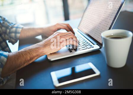 Quand l'inspiration frappe, courez à pleine vitesse. Gros plan d'un jeune créateur travaillant sur un ordinateur portable dans un bureau moderne. Banque D'Images