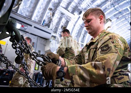 ÉTATS-UNIS L'Airman de la Force aérienne de classe 1st Derek Keller, un charmeur d'aéronefs affecté à l'escadron de transport aérien expéditionnaire 816th, assure la sécurité d'un système de fusée d'artillerie de grande mobilité (HImars), affecté au bataillon 3rd, 157th, Régiment d'artillerie de campagne, à l'intérieur de la soute de cargaison C-17 Globemaster III, Pendant l'opération Agile Spartan II à la base aérienne d'Ali Al Salem, Koweït, 16 mars 2022. Les membres ont participé à l'opération Agile Spartan (OAS) II, une opération conjointe et multinationale de grande envergure axée sur les tests opérationnels et l'évaluation des compétences de base d'Agile combat Employment. Banque D'Images