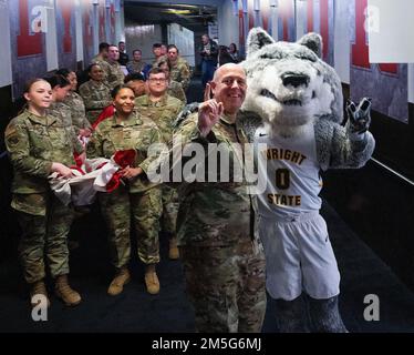 La mascotte de l'État Wright, Rowdy Raider et le colonel Patrick Miller, commandant de l'escadre de la base aérienne 88th et de la base aérienne Wright-Patterson, posent avec des aviateurs sur 16 mars 2022, Avant de porter un grand drapeau américain sur le sol de l’Université de Dayton Arena pour la cérémonie d’ouverture du tournoi de basketball masculin de la NCAA entre Wright State et Bryant. Wright State, une équipe locale dont le campus borde Wright-Patterson, a gagné le jeu et a avancé à la prochaine partie de jeu de tournoi. Banque D'Images