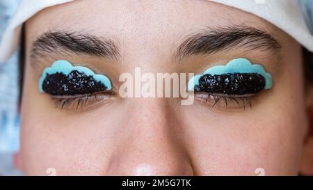 Gros plan portrait d'une femme sur la procédure de laminage et de coloration des cils. Maquillage permanent. Banque D'Images