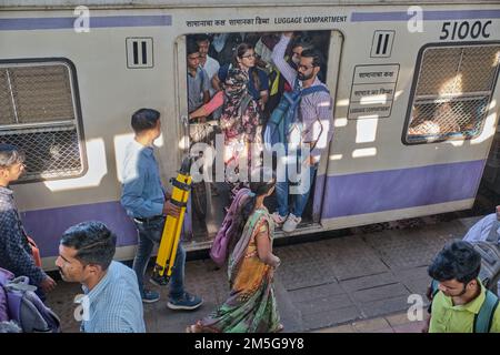 Un train de banlieue Western Railway local s'est arrêté à la gare de Dadar, Mumbai, Inde, les passagers bondés dans la porte ouverte du coffre à bagages Banque D'Images