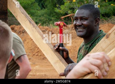 Un soldat de la Brigade des ingénieurs de la Force de défense du Rwanda sourit tout en travaillant avec des ingénieurs de la compagnie Wahoo 623rd Engineer de la Garde nationale de l'Armée du Nebraska, 16 mars, à Gako, au Rwanda. (Photo de la Garde nationale aérienne du Nebraska par le lieutenant-colonel Kevin Hynes) Banque D'Images