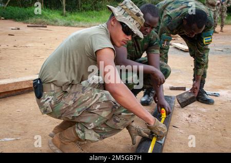 Jayden Askew, spécialiste de la maçonnerie et de la menuiserie de la Compagnie des ingénieurs en 623rd, travaille avec deux ingénieurs de la Force de défense du Rwanda pour couper des planches en bois à la bonne taille. Le soldat de la Garde nationale du Nebraska était l'un des nombreux ingénieurs basés à Wahoo qui se sont rendus au Rwanda en mars pour participer à un exercice médical/ingénieur dans le cadre du Programme de partenariat d'État de la Garde nationale. (Photo de la Garde nationale aérienne du Nebraska par le lieutenant-colonel Kevin Hynes) Banque D'Images