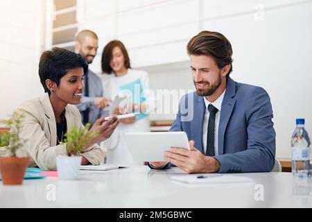 Discuter de leurs plans de réussite. professionnels utilisant des tablettes numériques lors d'une réunion de bureau. Banque D'Images