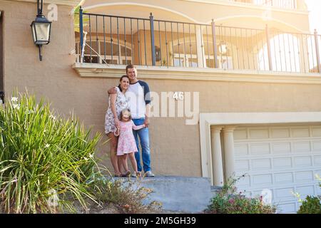 L'amour d'une famille est la plus grande bénédiction de vie. Portrait d'une famille heureuse debout à l'extérieur de leur maison. Banque D'Images