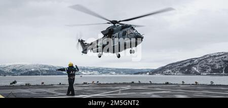Un aviateur de la Royal Netherlands Air Force facilite l'atterrissage d'un hélicoptère AS-532U2 Cougar lors de l'exercice Cold Response 2022, 17 mars 2022. L'aviateur est affecté au HNLMS de Rotterdam et l'hélicoptère est affecté au 300 Escadron du Commandement de l'hélicoptère de défense de la Royal Netherlands Air Force. L'exercice Cold Response '22 est un exercice biennal de préparation nationale et de défense norvégien qui a lieu dans toute la Norvège, avec la participation de chacun de ses services militaires, ainsi que de 26 autres nations alliées de l'Organisation du Traité de l'Atlantique Nord et partenaires régionaux. Banque D'Images