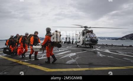 ÉTATS-UNIS Marines avec le concept de peloton Jaeger (Hunter) déchargez le matériel d'une Force aérienne royale des pays-Bas AS-532U2 Cougar à bord du navire quai de la plate-forme d'atterrissage, HNLMS Rotterdam (L800), pendant l'exercice Cold Response 2022, 17 mars 2022. Les Marines sont affectés au 3rd Bataillon, 6th Marine Regiment, 2D Marine Division, II Marine Expeditionary Force. L'exercice Cold Response '22 est un exercice biennal de préparation nationale et de défense norvégien qui a lieu dans toute la Norvège, avec la participation de chacun de ses services militaires, ainsi que de 26 autres nations alliées de l'OTAN et partenaires régionaux. Banque D'Images