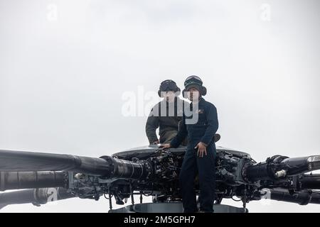 ÉTATS-UNIS Corps maritime lance le Cpl Nathaniel Vecino et le Cpl Yao Lin fixent les pales de rotor d'un Super étalon CH-53E pendant l'exercice Cold Response 2022, Bardufoss Air Station, Norvège, 17 mars 2022. Le Vecino et le Yao sont des mécaniciens de cellule affectés à l'escadron 366 de l'hélicoptère marin lourd. L’exercice Cold Response ’22 est un exercice biennal qui a lieu dans toute la Norvège, avec la participation de chacun de ses services militaires, ainsi que de 26 autres nations alliées et partenaires régionaux de l’Organisation du Traité de l’Atlantique Nord. Banque D'Images