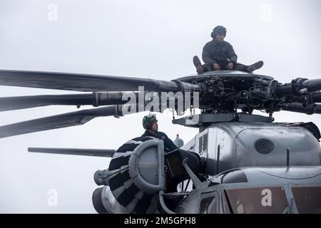 ÉTATS-UNIS Le Cpl Yao Lin et le Cpl Nathaniel Vecino du corps maritime fixent les pales du rotor d'un Super étalon CH-53E pendant l'exercice Cold Response 2022, Bardufoss Air Station, Norvège, 17 mars 2022. Le Vecino et le Yao sont des mécaniciens de cellule affectés à l'escadron 366 de l'hélicoptère marin lourd. L’exercice Cold Response ’22 est un exercice biennal qui a lieu dans toute la Norvège, avec la participation de chacun de ses services militaires, ainsi que de 26 autres nations alliées et partenaires régionaux de l’Organisation du Traité de l’Atlantique Nord. Banque D'Images