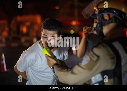 Un policier thaïlandais effectue un test d'alcoolémie au point de contrôle de Chiang Mai. Le Centre pour la prévention et la réduction des accidents de la route a été créé pendant le Festival du nouvel an 2023, la période de contrôle intensif de 7 jours allant du 29 décembre 2022 au 4 janvier 2023. Plus de 50 000 agents de police doivent mettre en place des points de contrôle pour faciliter les lois sur la circulation et prendre soin de la sécurité des personnes. Ils travailleront tout au long du festival sans vacances, en se concentrant sur 4 charges selon la politique gouvernementale : conduire en état d'ébriété, conduire trop vite, et ne pas être fatigué Banque D'Images