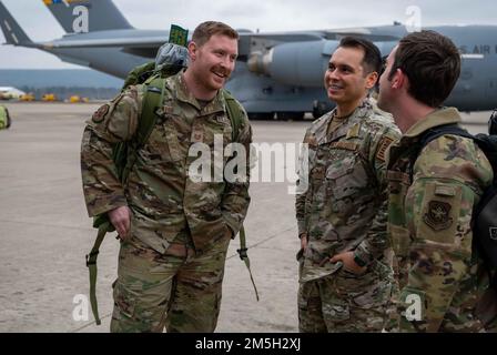 Les membres du Groupe des opérations de mobilité aérienne 721st saluent chacun d'eux après leur retour d'un déploiement, à la base aérienne de Ramstein, en Allemagne, le 17 mars 2022. Ces membres faisaient partie d'une équipe de sept membres affectée à l'AMOG de 721st qui est revenu d'un déploiement en Pologne, à côté de l'escadre des opérations aériennes au sol de 435th, pour soutenir les alliés et les partenaires de la région. En tant que partenaires de l'OTAN, les États-Unis travaillent régulièrement avec les forces polonaises pour améliorer la préparation collective, l'interopérabilité et renforcer les relations. Banque D'Images