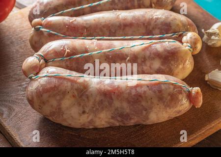 Gros plan de chorizos crus sur une plaque de découpe , saucisses argentines typiques faites avec du porc mélangé et de la viande de boeuf. Banque D'Images