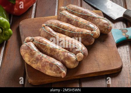 Chorizos cru sur une plaque de découpe , saucisses argentines typiques faites avec du porc mélangé et de la viande de boeuf. Banque D'Images